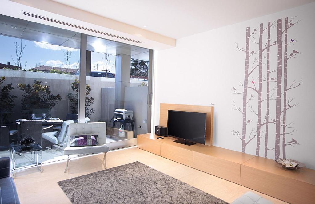 sala de estar con TV y ventana grande en Boutique Stays - The Residence, en Melbourne