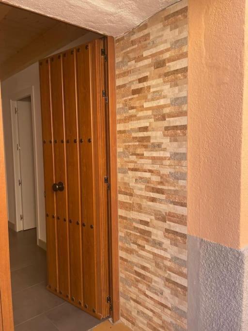 a room with a brick wall and a wooden closet at Morada del Santo in Fontiveros