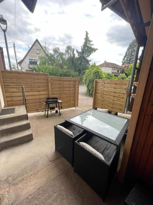 un patio avec une table et des chaises et une clôture dans l'établissement Appartement route du vin, à Dambach-la-Ville