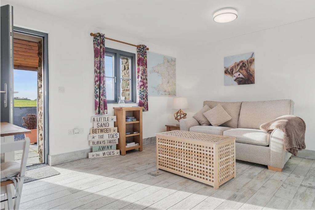 un soggiorno con un divano e un tavolo di Grassholm Cottage with Hot Tub - Dog Friendly a Haverfordwest