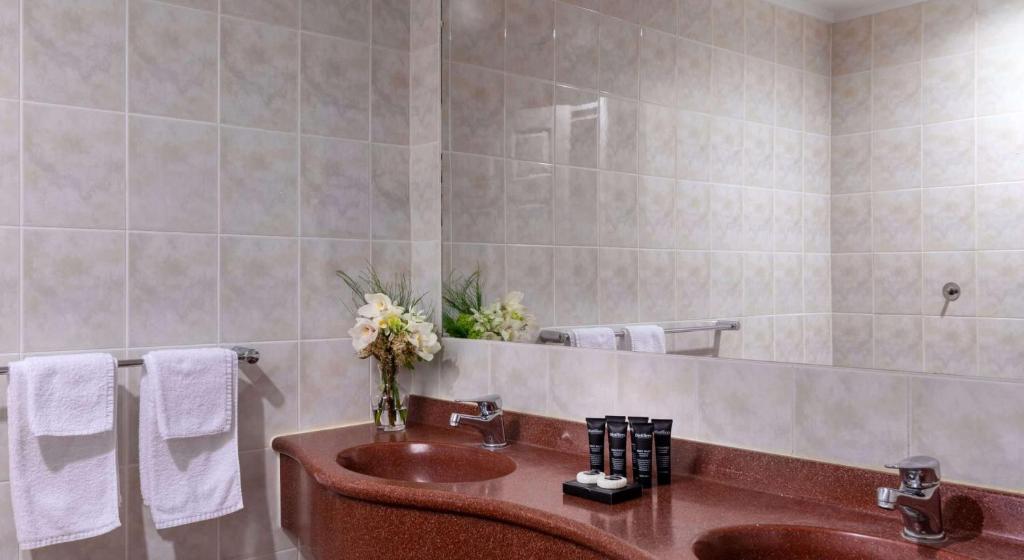 W łazience znajduje się umywalka i lustro. w obiekcie Arawa Park Hotel, Independent Collection by EVT w mieście Rotorua
