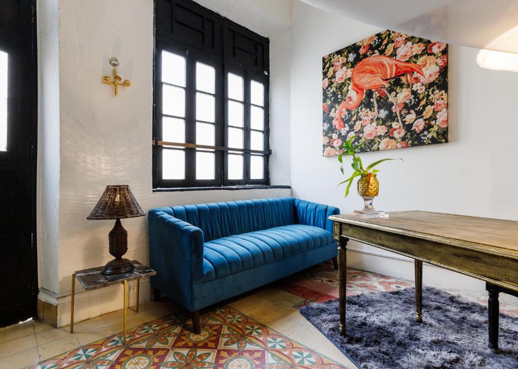 un salon avec un canapé bleu et une table dans l'établissement Casa Paxi, à Mérida