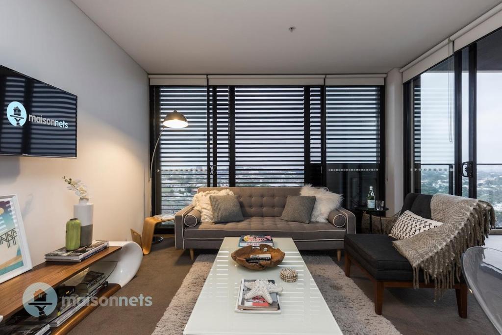 a living room with a couch and a table at Redfern One Bedroom Apartment with Views in Sydney