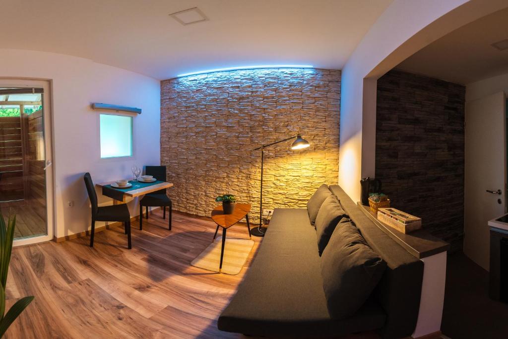 a living room with a couch and a brick wall at Savna cimr in Mežica