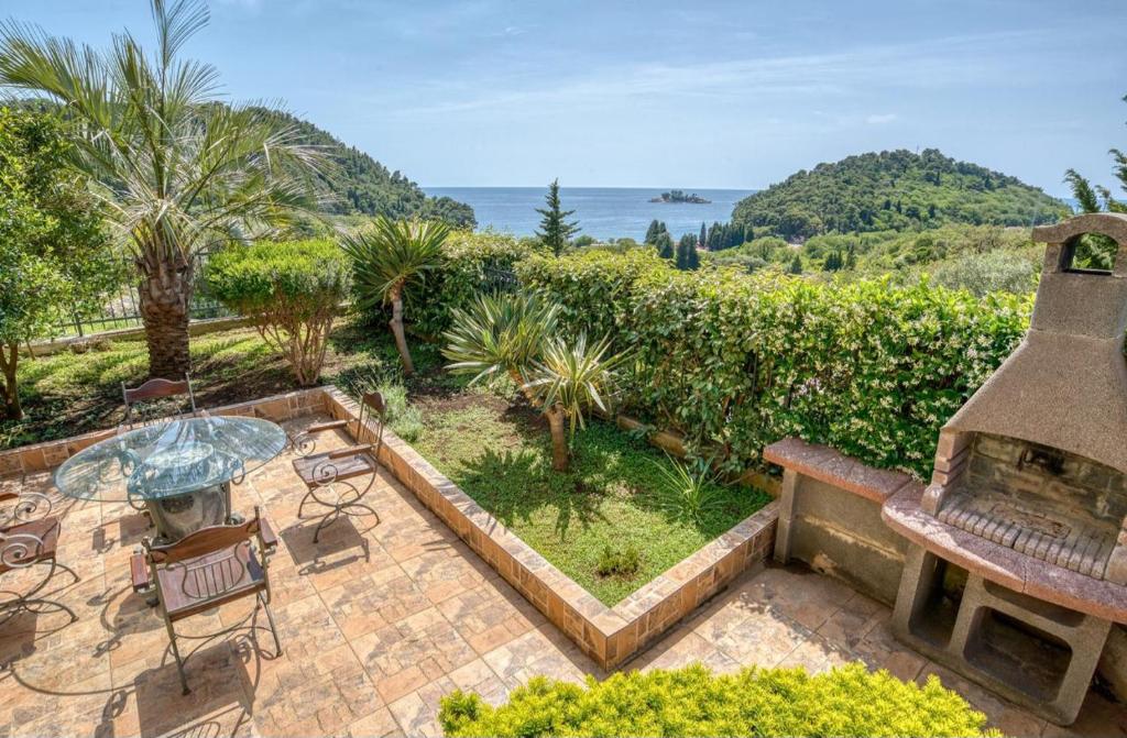 an outdoor patio with a fireplace and a table and chairs at The view villa in Petrovac na Moru