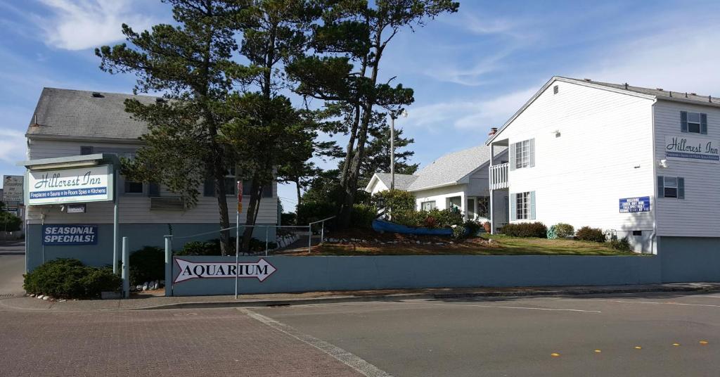 um edifício branco com um sinal em frente em Hillcrest Inn em Seaside