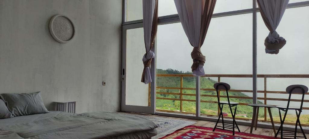 a bedroom with a bed and a large window at Penginapan Homestay Sikunir - Bukit Bintang Dusun Musilan in Kejajar