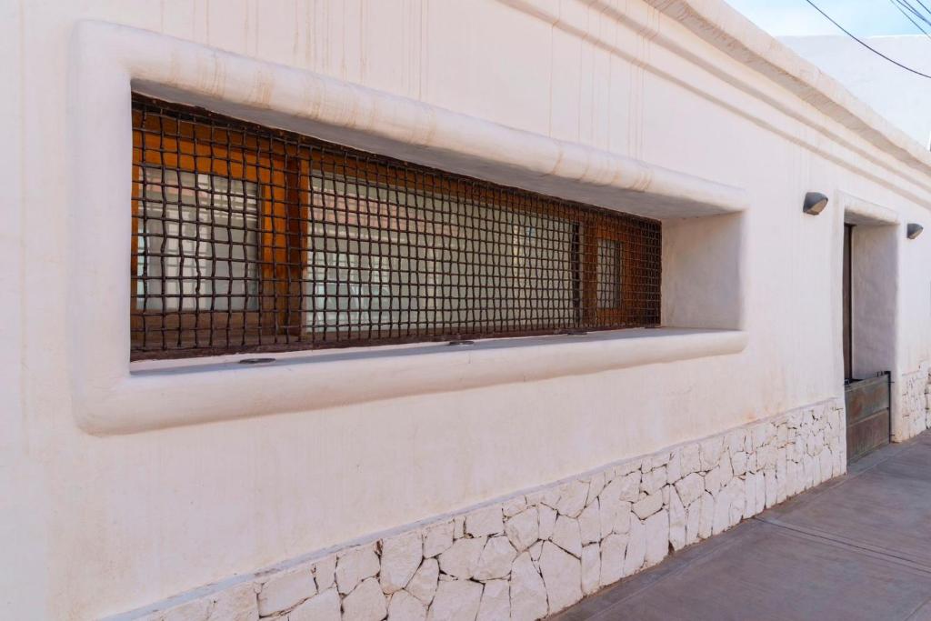 a window on the side of a white building at Casa Bernardina in Tilcara