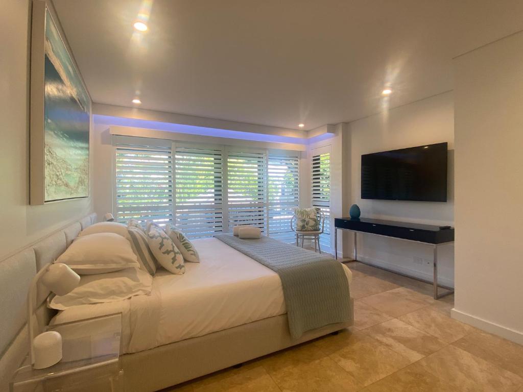 TV a/nebo společenská místnost v ubytování AQUA Beachfront Villa Port Douglas