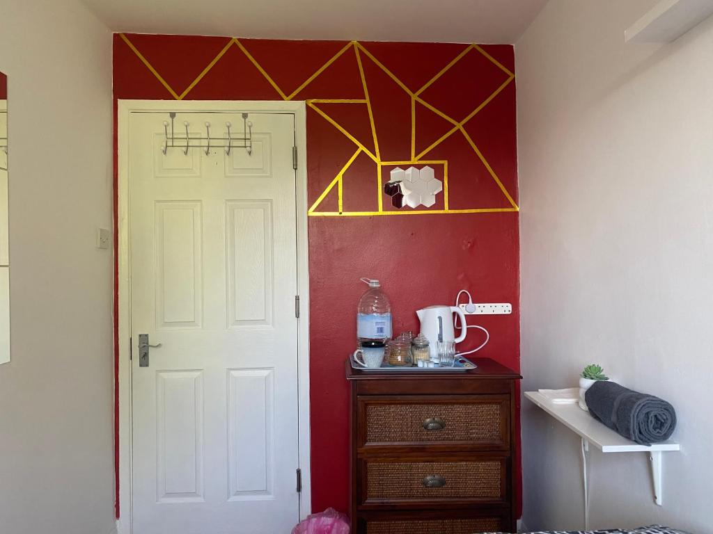 Habitación con puerta blanca y pared roja en 1 Cozy Single Bedroom With Hot Drinks, en Reading