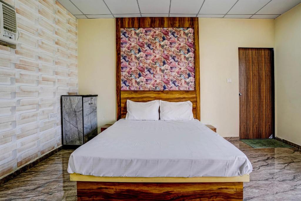 1 dormitorio con 1 cama y un edredón grande en la pared en Super OYO Neelkanth Hotel And Restaurant en Vadodara