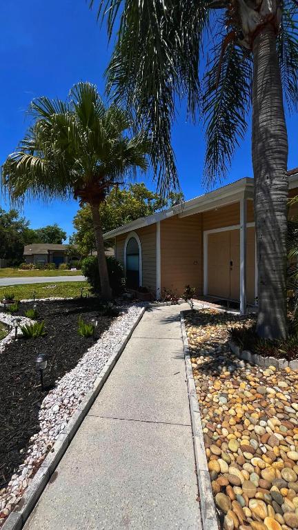 ein Haus mit einer Palme und einem Gehweg in der Unterkunft Your home away from home ! in Sarasota