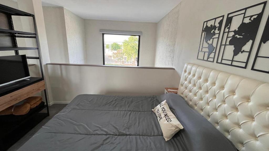 1 dormitorio con 1 cama y TV en Altos de Belgrano - Vicuña Mackenna en 