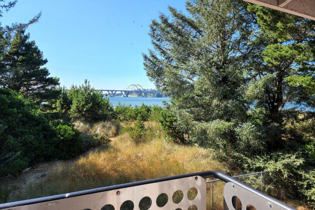 Una vista de un río con un puente al fondo. en Alsea Shores! Dog Friendly and Hot Tub!, en Waldport
