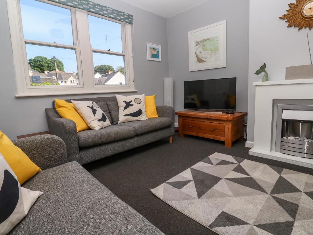 een woonkamer met een bank en een televisie bij 8 Rosewall Cottages in St Ives