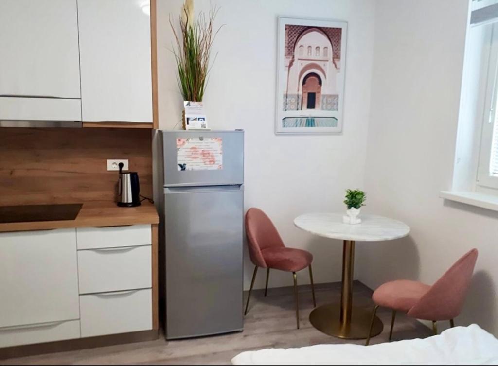 a kitchen with a small table and a refrigerator at Ljubljana Central Studio with Free Parking in Ljubljana