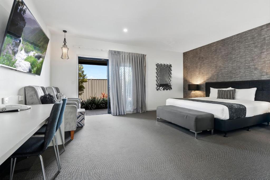 洛坎普頓的住宿－Quality Resort Parkhurst，酒店客房配有一张床、一张书桌和一张书桌。