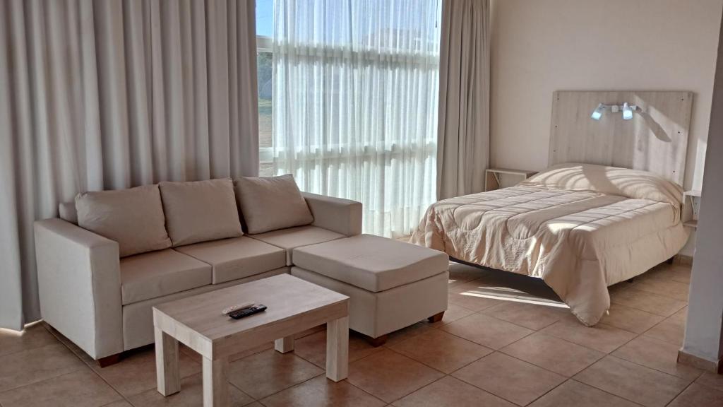 ein Wohnzimmer mit einer Couch und einem Bett in der Unterkunft Las Acacias suites in San Lorenzo