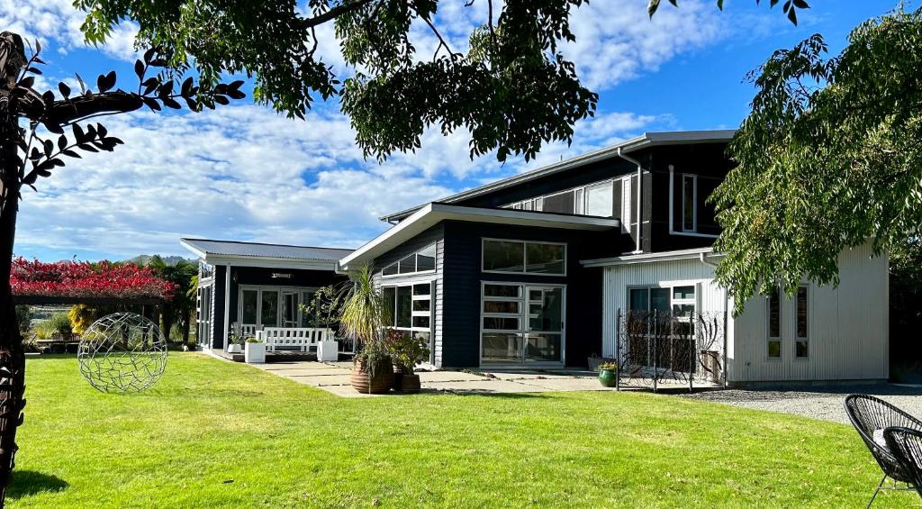 a black and white house with a yard at Peppertree lodge in Havelock North