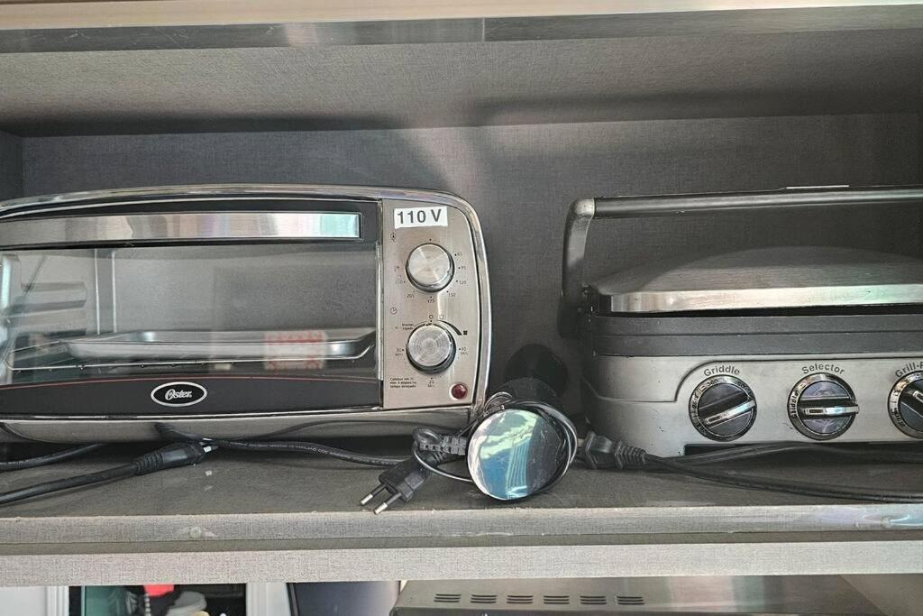 a toaster and a toaster oven sitting on a shelf at Casa de luxo c/piscina 4 quartos 2 banheiras. in Rio de Janeiro