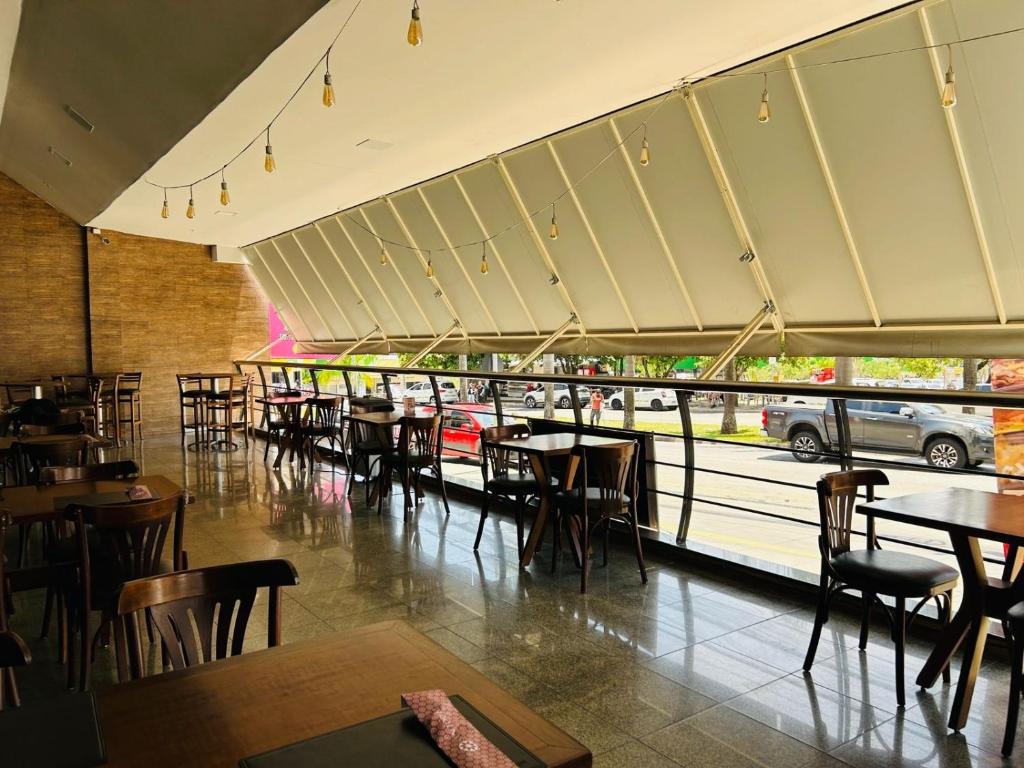 a restaurant with tables and chairs and a view of a street at Flat confortável e econômico hotel condomínio cristal place in Goiânia