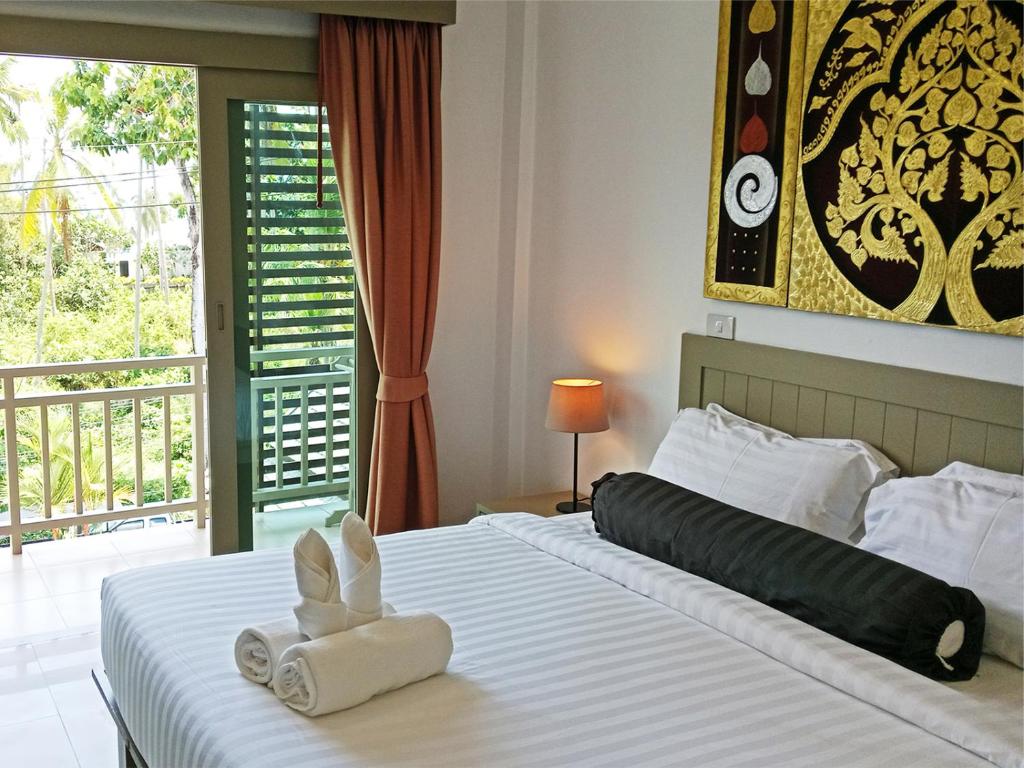 Un dormitorio con una cama con un juguete de conejito. en Ampha Place Hotel, en Mae Nam