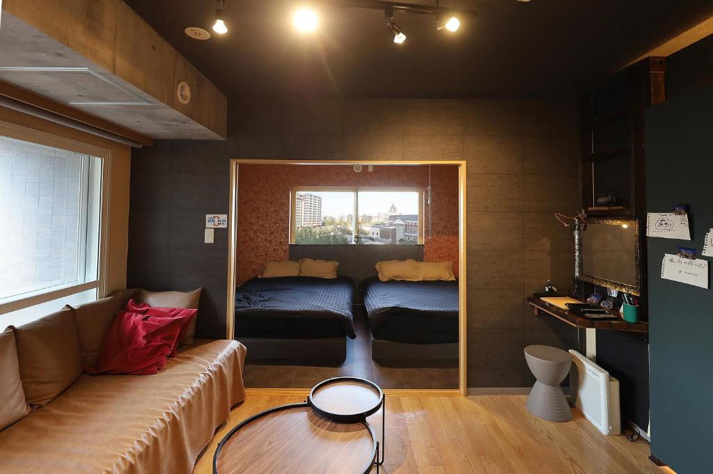 - un salon avec un canapé et un lit dans l'établissement BIOSvilla522-Sapporo Susukino Night- 1Room W-beds2&S-beds2 6Persons, à Sapporo