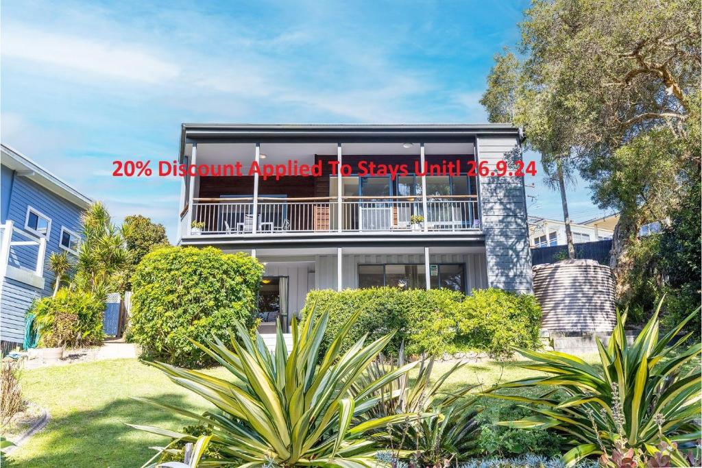 an apartment building with a sign on the side of it at Baggies On Dutchies, 9 Burbong Street - Large Pet Friendly house with spectacular waterviews, Wi-Fi and air con in Nelson Bay