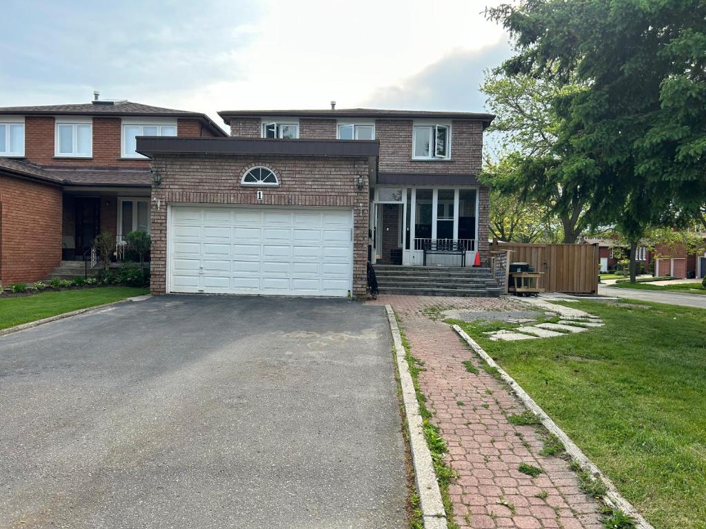 a brick house with a garage and a driveway at KenHouse in Toronto