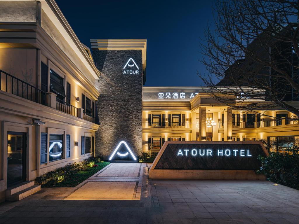 hotel z napisem oznaczonym kątowym hotelem w nocy w obiekcie Atour Hotel Shanghai World Expo West Gaoke Road w Szanghaju