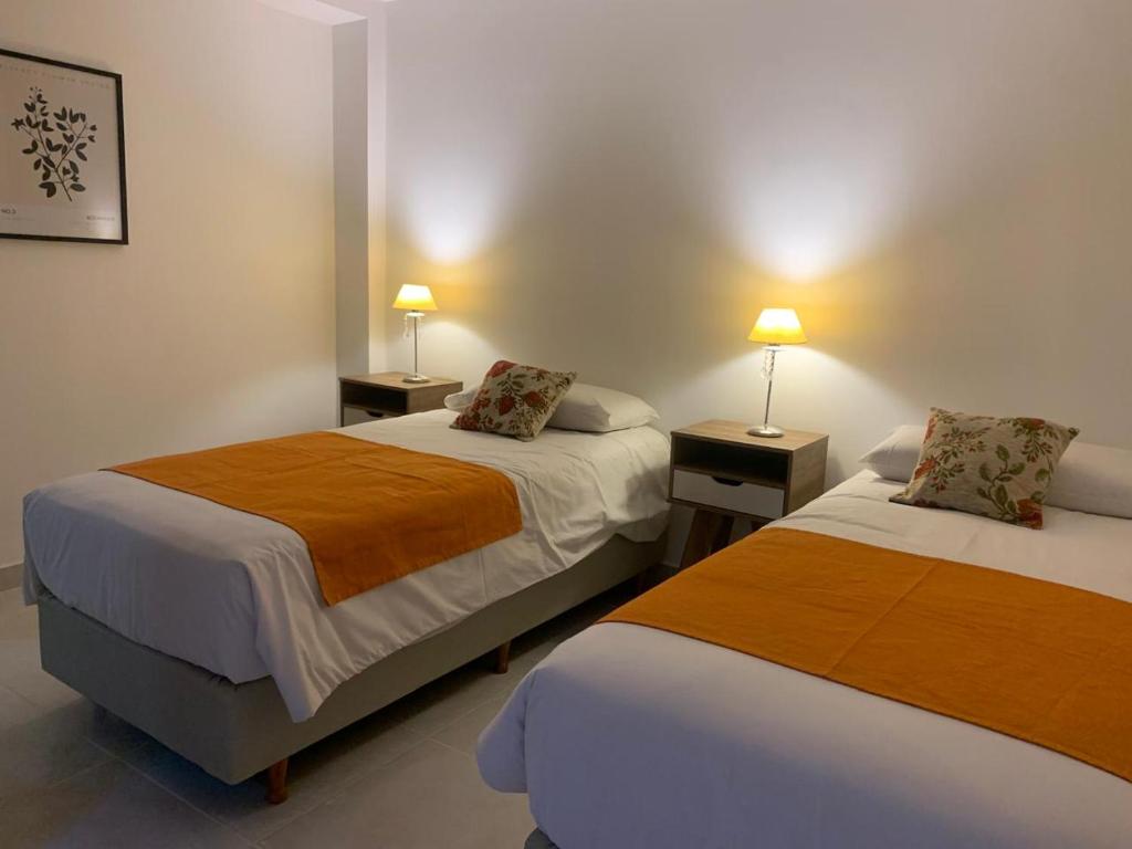2 camas en una habitación con 2 lámparas en las mesas en Bouchard-Ushuaia Flat, en Ushuaia