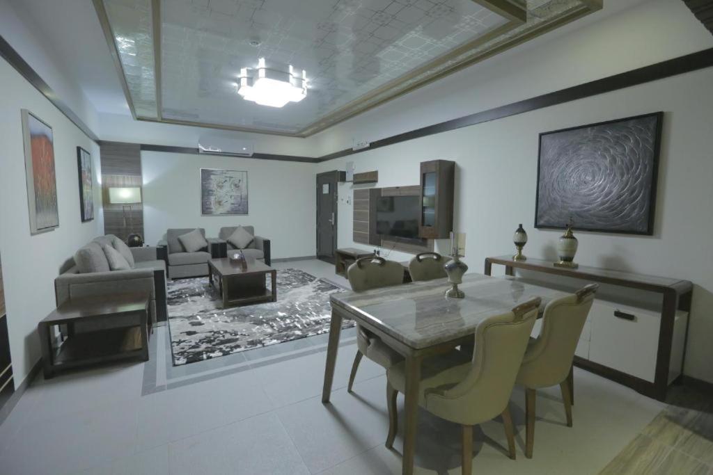a living room with a dining table and a couch at Niyaf Serviced Apartments in Khamis Mushayt