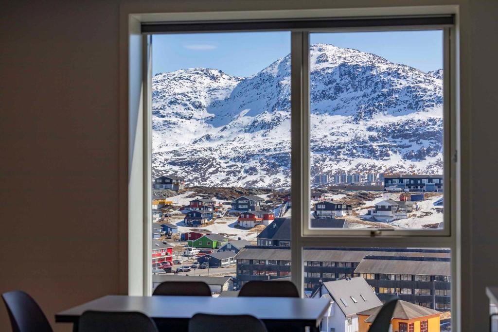 una finestra con vista su una montagna innevata di Hotel Aurora Apartments a Nuuk