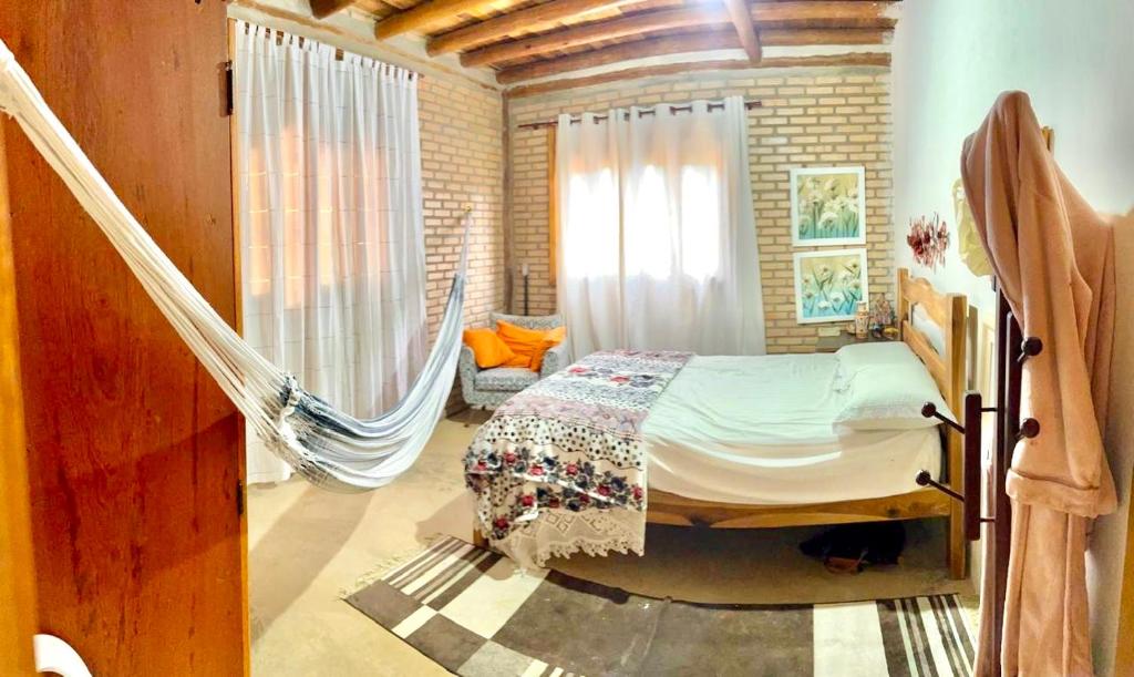 a bedroom with a hammock in a room at Cabana Charme Guará- 500 metros do centro in Guaramiranga