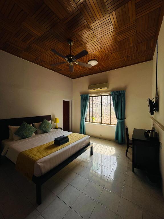 a bedroom with a large bed with a wooden ceiling at Birdcage Boutique in Phnom Penh