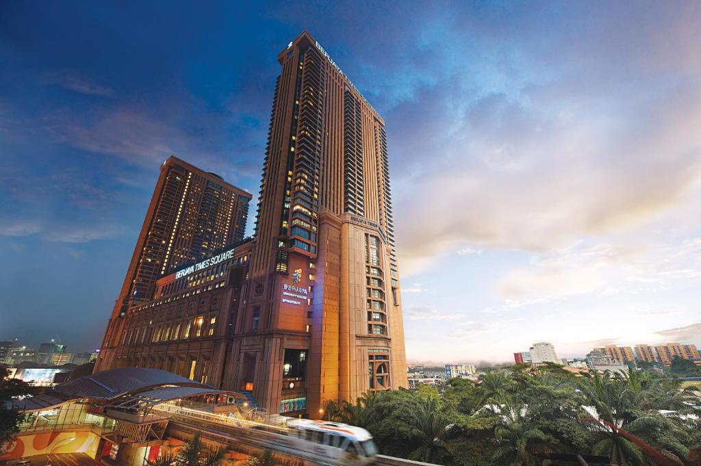 吉隆坡的住宿－Berjaya Times Square Hotel, Kuala Lumpur，前面有一辆公共汽车的高层建筑