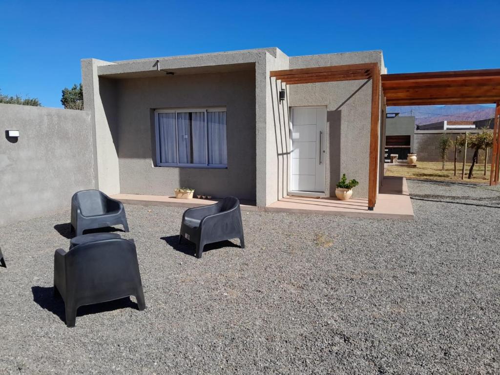 un patio con 2 sillas negras y una casa en DEPARTAMENTOS Del OESTE, en Villa Unión