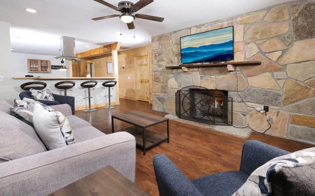 a living room with a stone wall with a fireplace at Big Oak Hideaway in Gatlinburg