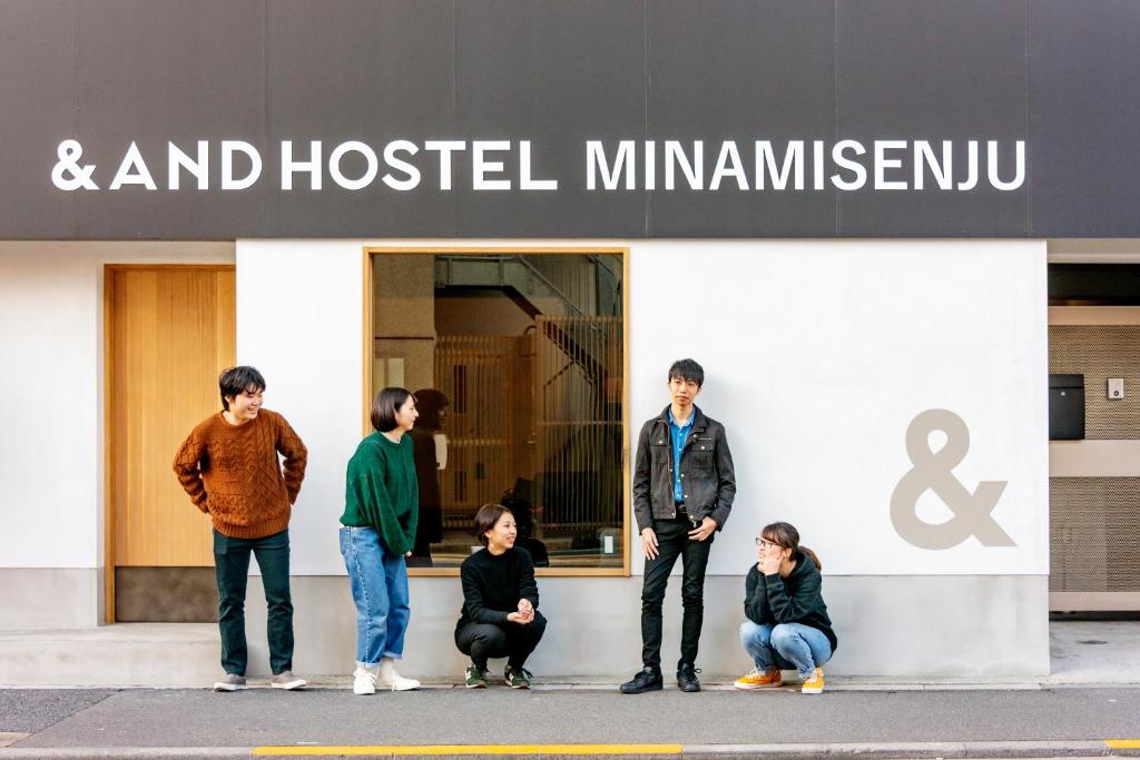 a group of people standing in front of a store at &AND HOSTEL MINAMISENJU in Tokyo