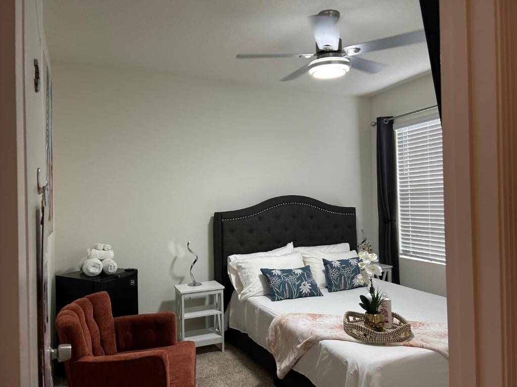 una camera con letto, ventilatore a soffitto e sedia di Home SWEET HOME a Davenport