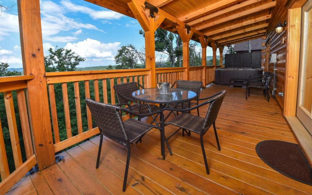 a patio with a table and chairs on a wooden deck at A Wildflower Retreat in Gatlinburg