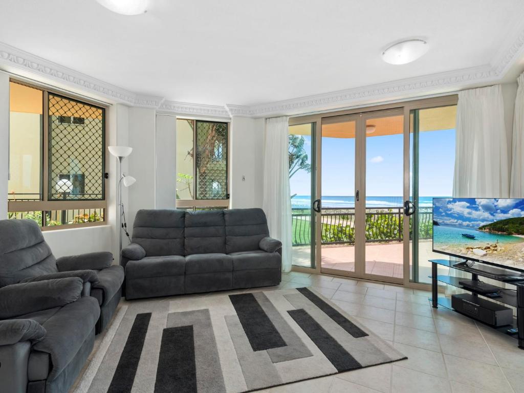a living room with a couch and a flat screen tv at Casa del Rey 1 in Gold Coast