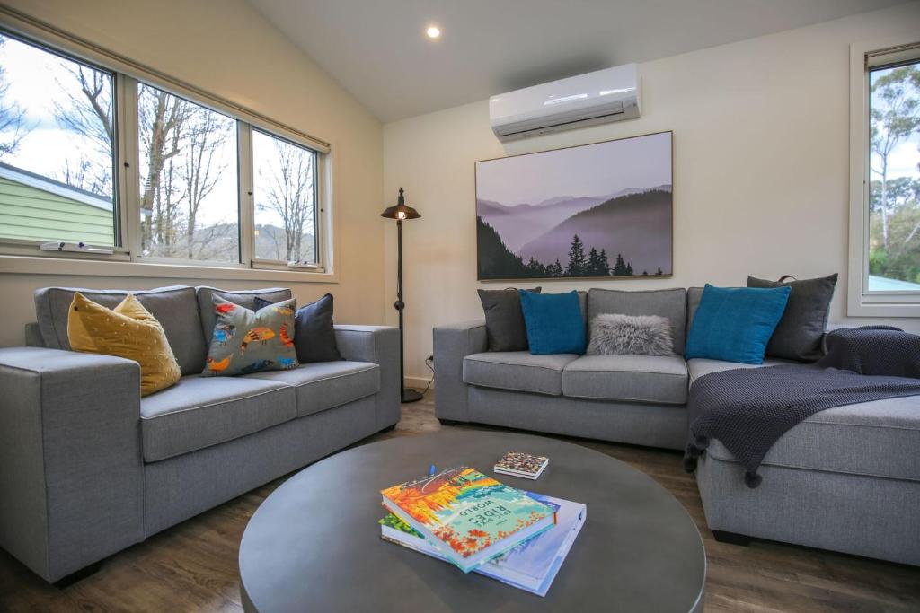 a living room with two couches and a table at A Pear Tree Loft in Bright