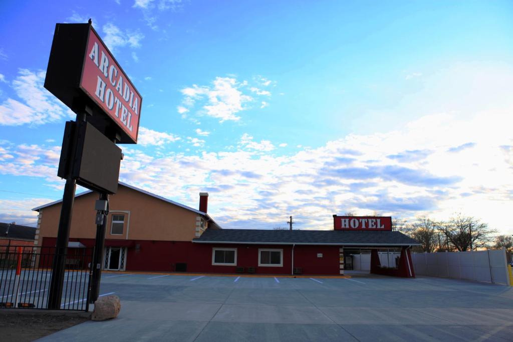 a building with a red sign in front of it at Arcadia Hotel in Gering
