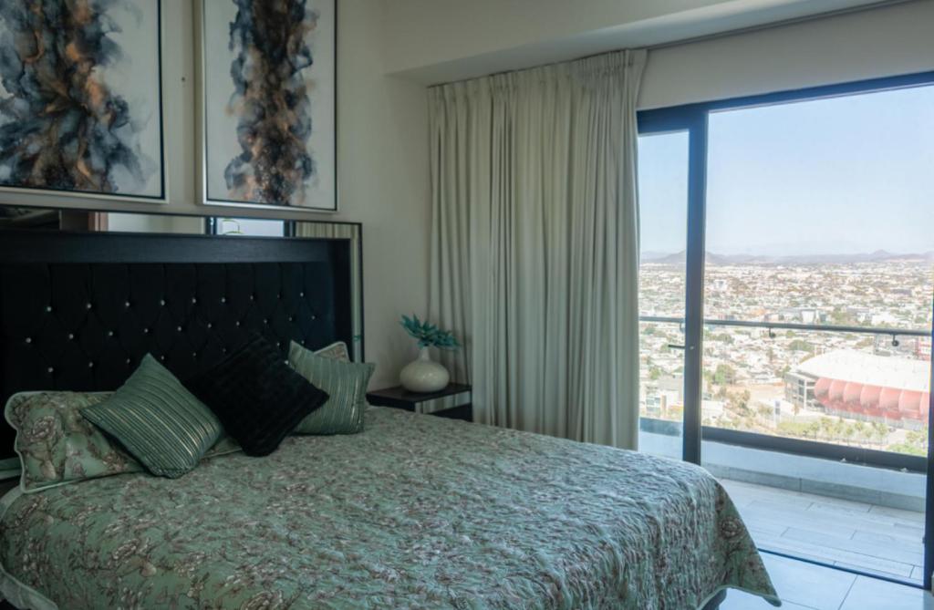 马萨特兰Altomare depa 2001的一间卧室，配有一张大床和一扇大窗户。