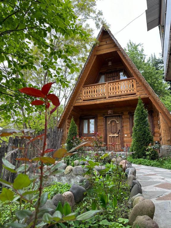 eine Blockhütte mit einem Garten davor in der Unterkunft Old Dili in Dilidschan