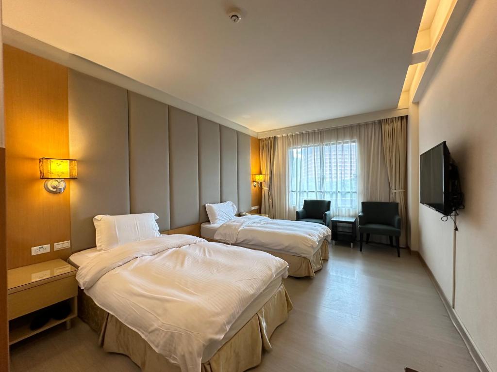 Habitación de hotel con 2 camas y TV de pantalla plana. en CHIENTAN Youth Hotel en Taipéi