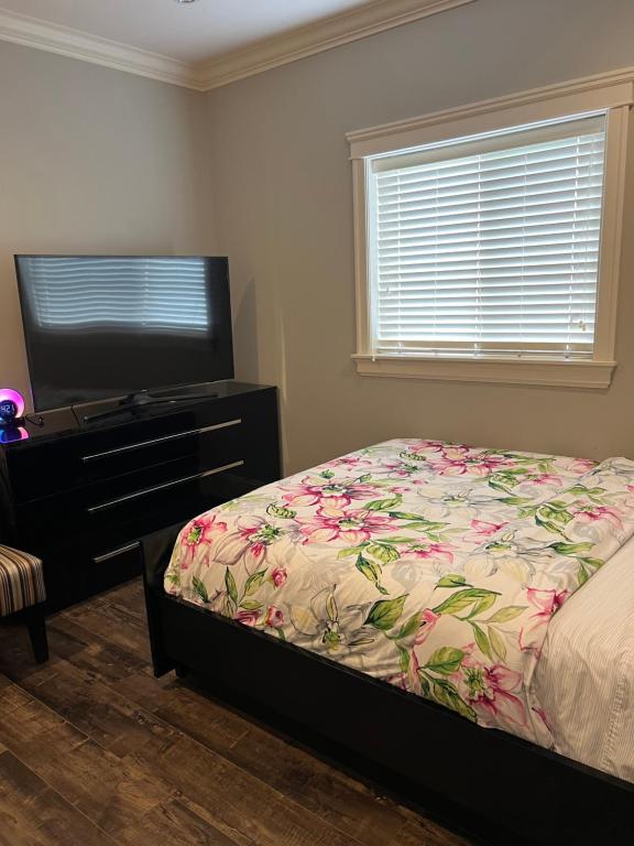 een slaapkamer met een bed en een flatscreen-tv bij Spacious !!! NEWER HOME 2 bedrooms Entire suite !! Near Airport !!!! in Abbotsford