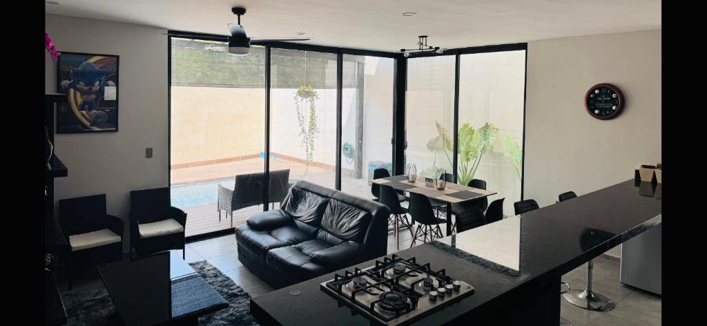 a kitchen and living room with a stove and a couch at Casa Auro in Mérida