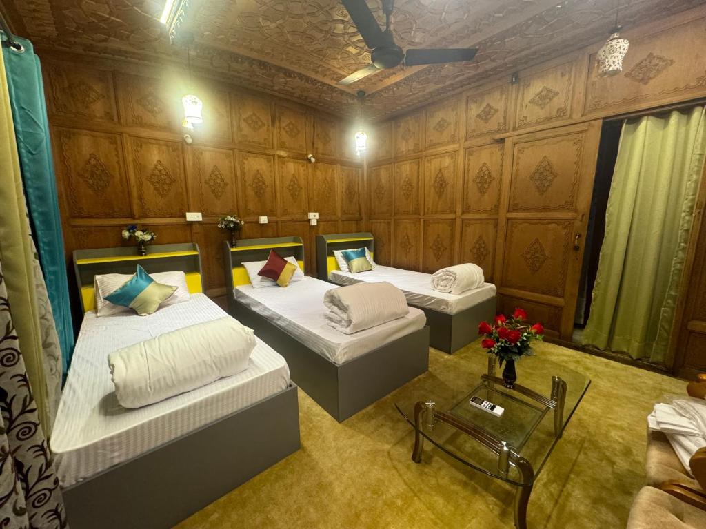 una camera con due letti e un tavolo di SoloSync - Hostel on the Boat a Srinagar